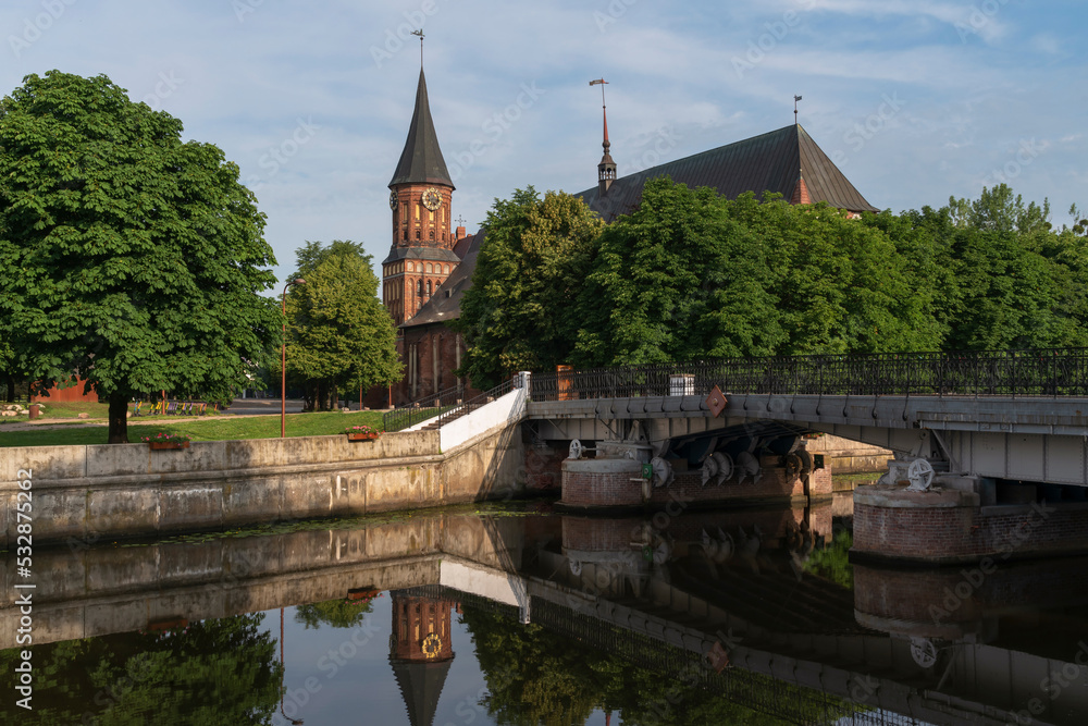 View of the Koningberg Cathedral on Immanuel Kant Island against the background of the Honey Bridge over the Pregolya River on a sunny summer day, Kaliningrad, Russia