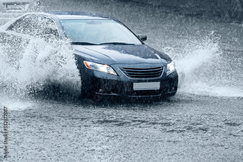 Canvas Print driving car on a wet road with splashing water. motion blur.