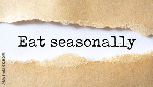 Eat seasonally message written under torn paper.