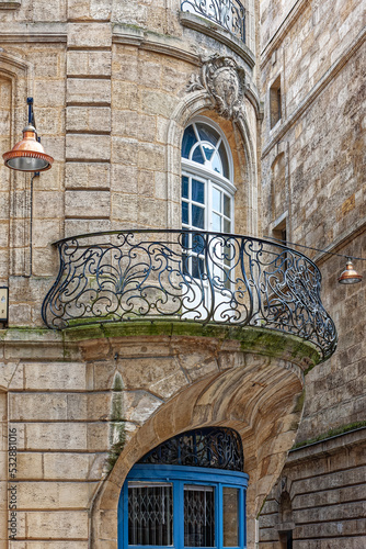 Antique balcony with openwork metal railings in the center of Bordeaux