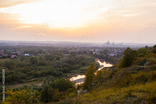 Panoramic view of the city of Ivano-Frankivsk. View of mountain hill and industrial power station oland behind at evening. Sunset over Ivano Frankivsk city in Ukraine. Landscape with hills and river.