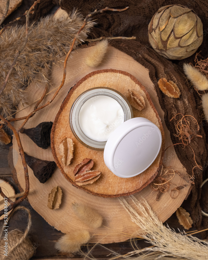 Opened glass cream jar on wood near natural decorations top view. Packaging Mockup Opened glass cream jar on wood near natural decorations top view. Packaging Mockup