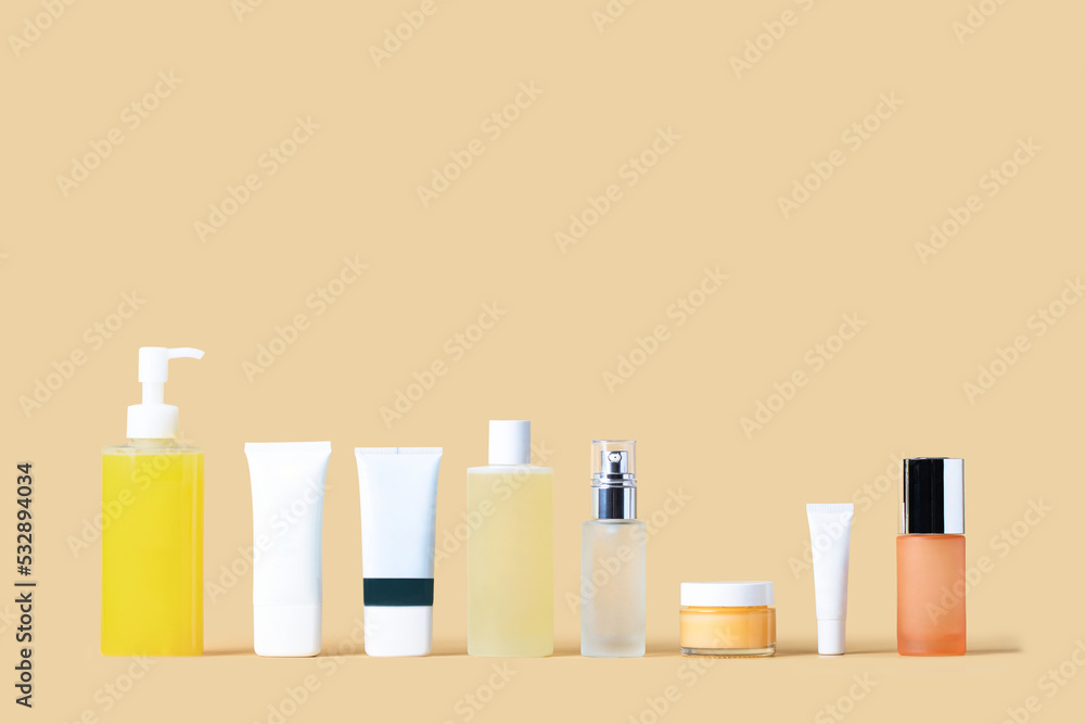 Cosmetic set of skincare routine for healthy radiant skin. Cleanser, gel, gommage, toner, essence, cream and spf treatment on  beige background. Beauty concept