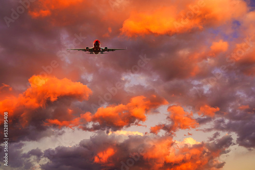 夕焼け雲の中を飛行する飛行機