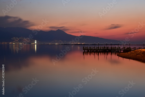 Panoromic city view with beautiful reflection after sunset, harmony of yellow and blue on uside and down