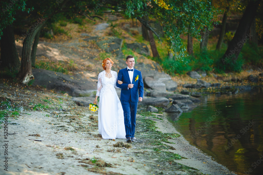 Young beautiful couple in a blue suit and white wedding dress with a bouquet Young beautiful couple in a blue suit and white wedding dress with a bouquet