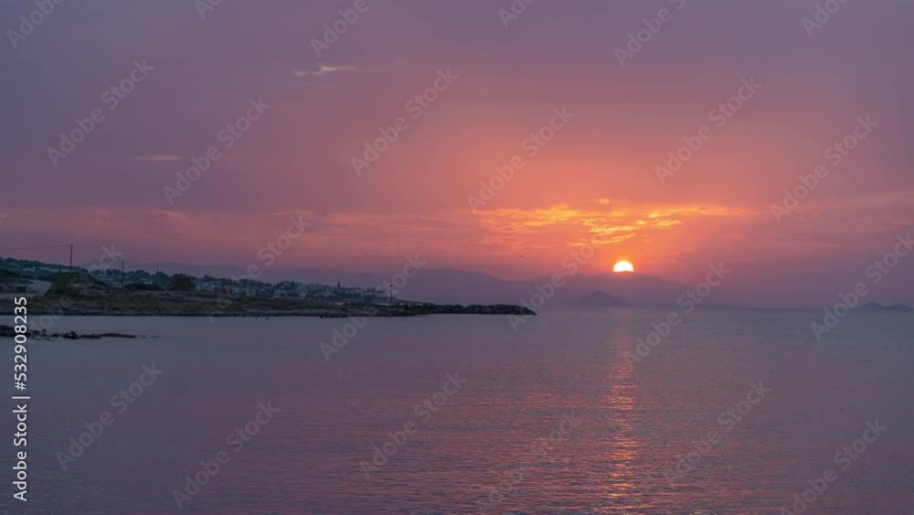 Timelapse 4K of sunset in the Greek island Aegina reflecting on the surface of the Aegean sea in Greece during Summer from light to dark
