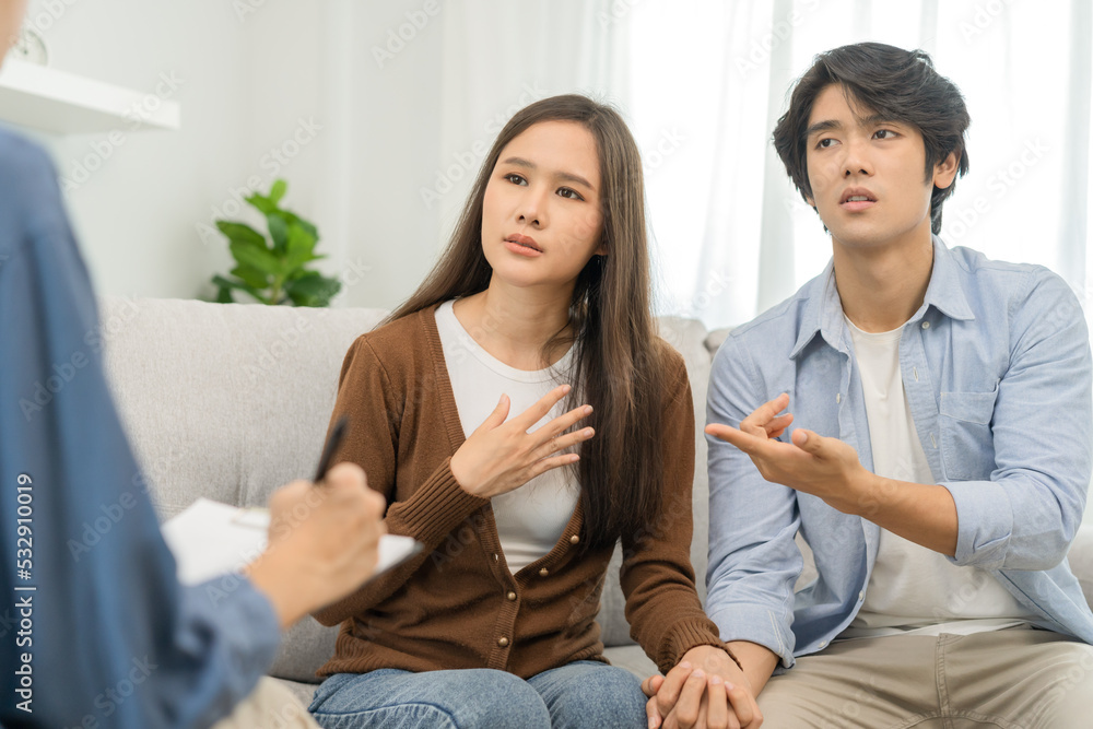 Psychology, depression asian young couple, patient consulting problem mental health with psychologist, psychiatrist at clinic together, husband encouraging by holding hand of wife, therapy health care Psychology, depression asian young couple, patient consulting problem mental health with psychologist, psychiatrist at clinic together, husband encouraging by holding hand of wife, therapy health care