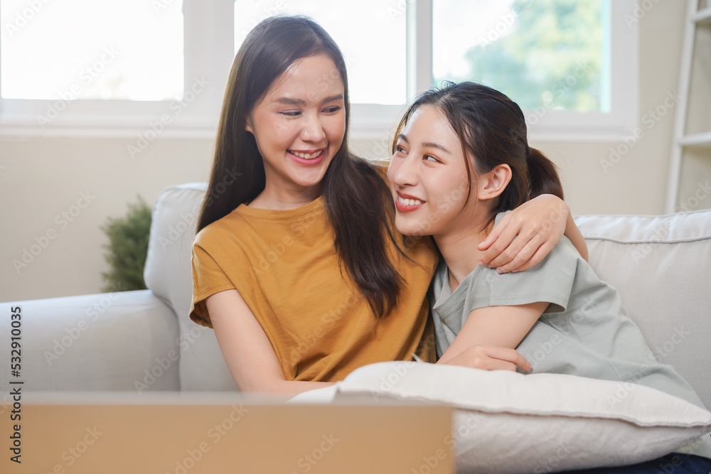 Happy lesbian, pleasure asian young two women, girl gay or close friend, couple love embrace, spending good time together, using laptop computer for entertainment on sofa at home. Activity of leisure. Happy lesbian, pleasure asian young two women, girl gay or close friend, couple love embrace, spending good time together, using laptop computer for entertainment on sofa at home. Activity of leisure.