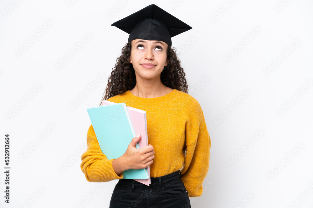 Arab university graduate woman holding books isolated on white background and looking up Arab university graduate woman holding books isolated on white background and looking up