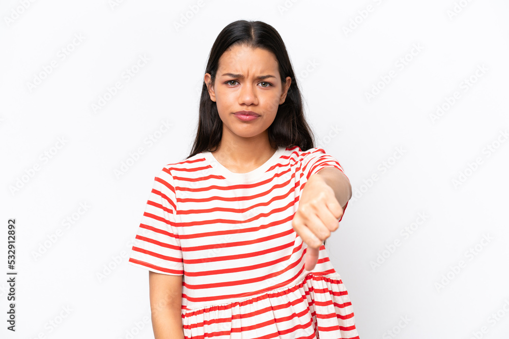 Young Colombian woman isolated on white background showing thumb down with negative expression Young Colombian woman isolated on white background showing thumb down with negative expression