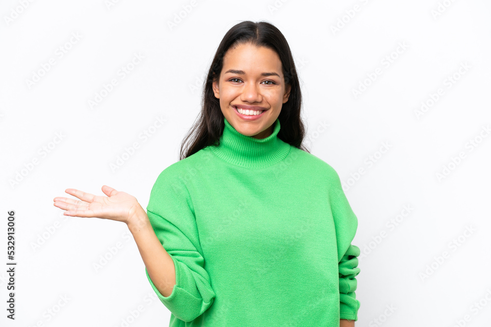 Young Colombian woman isolated on white background holding copyspace imaginary on the palm to insert an ad Young Colombian woman isolated on white background holding copyspace imaginary on the palm to insert an ad