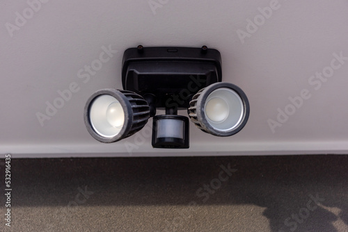 An outdoor security dual head flood light under the roof.