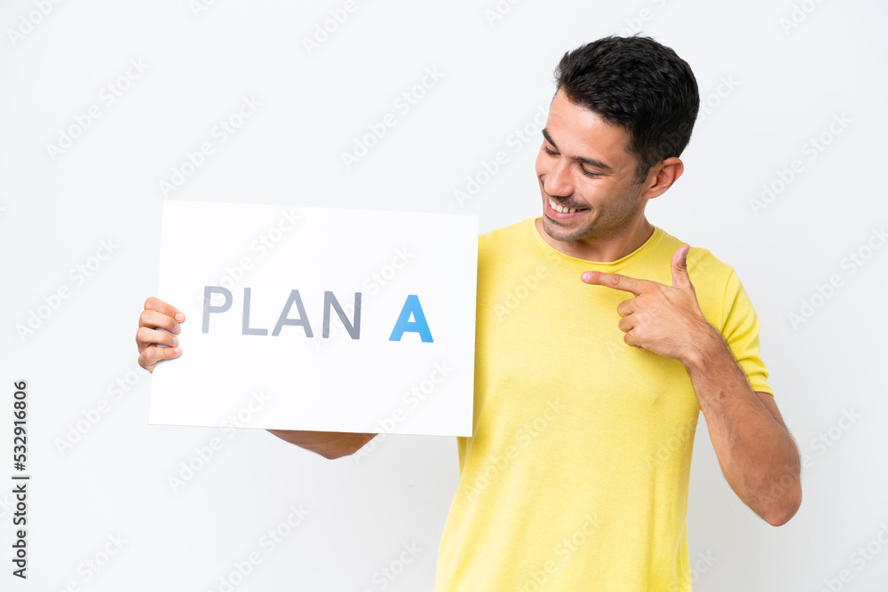 Young handsome man over isolated white background holding a placard with the message PLAN A and pointing it Young handsome man over isolated white background holding a placard with the message PLAN A and pointing it