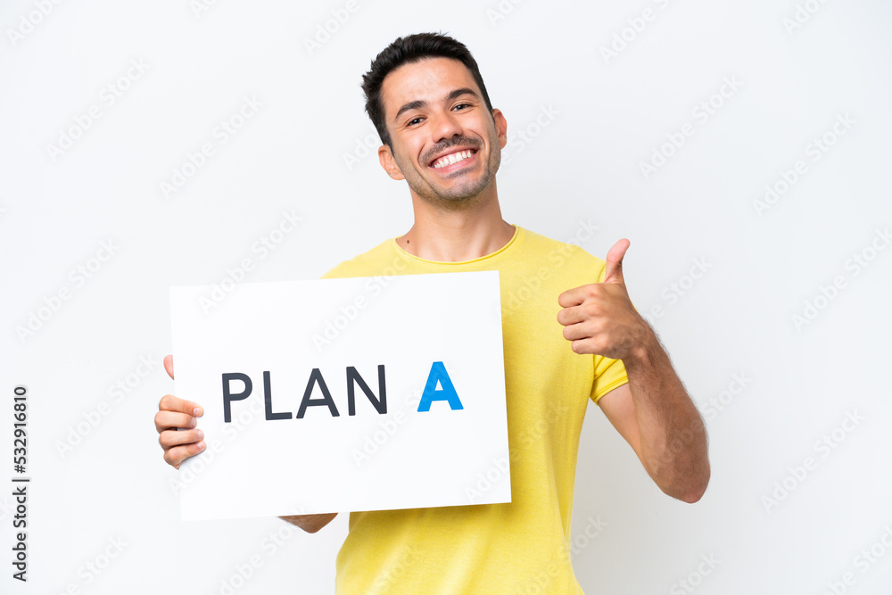 Young handsome man over isolated white background holding a placard with the message PLAN A with thumb up