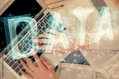 Double exposure of woman hands working on computer and data theme hologram drawing. Top View. Technology concept. © peshkova
