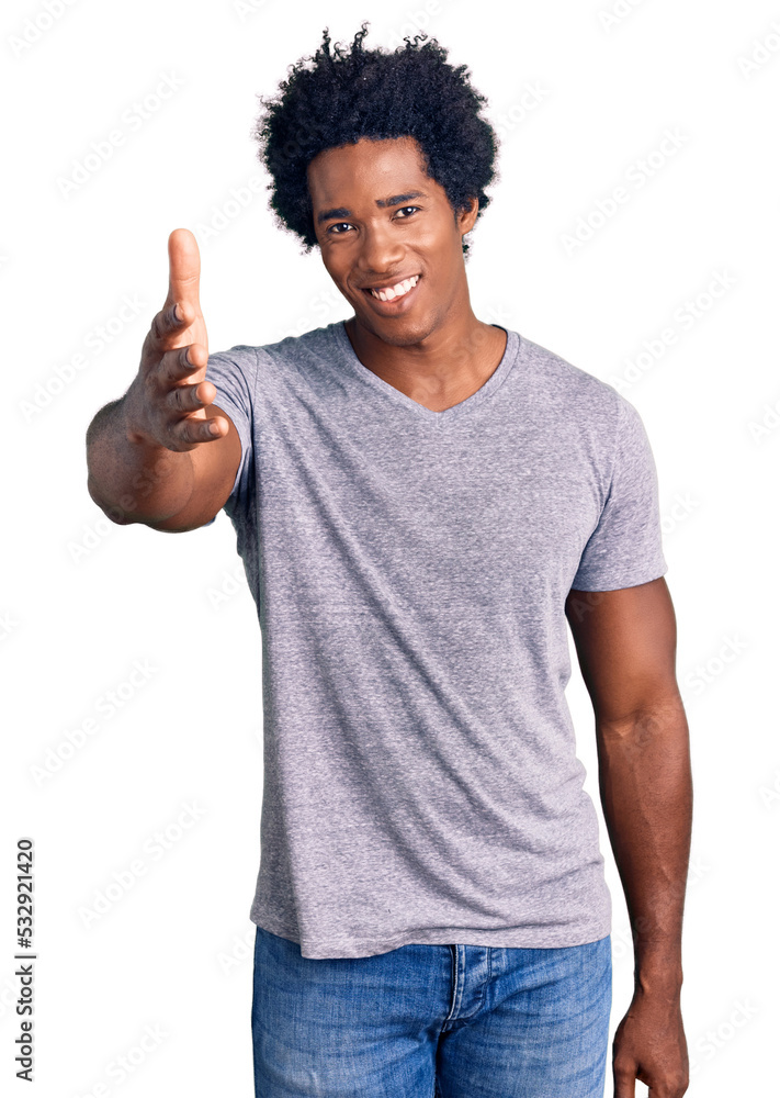Handsome african american man with afro hair wearing casual clothes smiling friendly offering handshake as greeting and welcoming. successful business. Handsome african american man with afro hair wearing casual clothes smiling friendly offering handshake as greeting and welcoming. successful business.