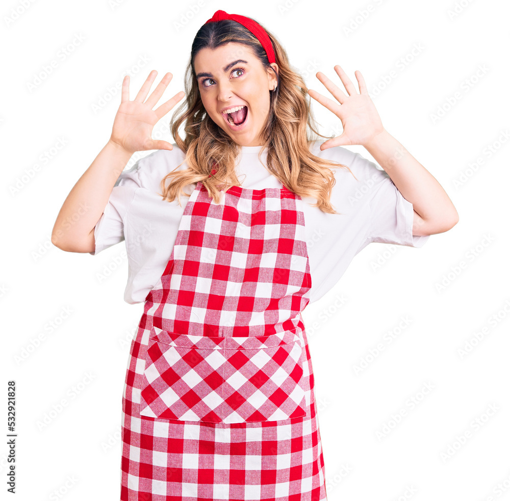 Young caucasian woman wearing apron showing and pointing up with fingers number ten while smiling confident and happy. Young caucasian woman wearing apron showing and pointing up with fingers number ten while smiling confident and happy.