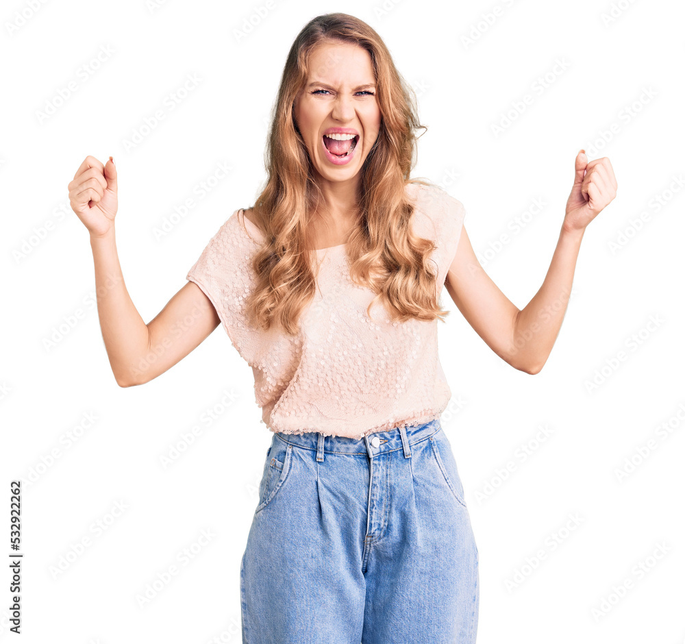 Young beautiful caucasian woman with blond hair wearing casual clothes angry and mad raising fists frustrated and furious while shouting with anger. rage and aggressive concept. Young beautiful caucasian woman with blond hair wearing casual clothes angry and mad raising fists frustrated and furious while shouting with anger. rage and aggressive concept.