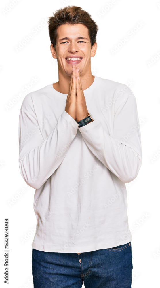Handsome caucasian man wearing casual white sweater praying with hands together asking for forgiveness smiling confident. Handsome caucasian man wearing casual white sweater praying with hands together asking for forgiveness smiling confident.