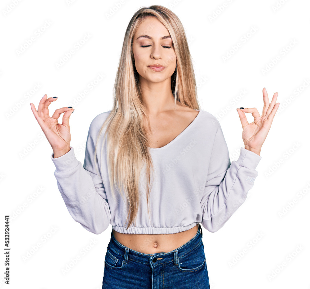 Beautiful young blonde woman wearing casual white sweater relax and smiling with eyes closed doing meditation gesture with fingers. yoga concept. Beautiful young blonde woman wearing casual white sweater relax and smiling with eyes closed doing meditation gesture with fingers. yoga concept.