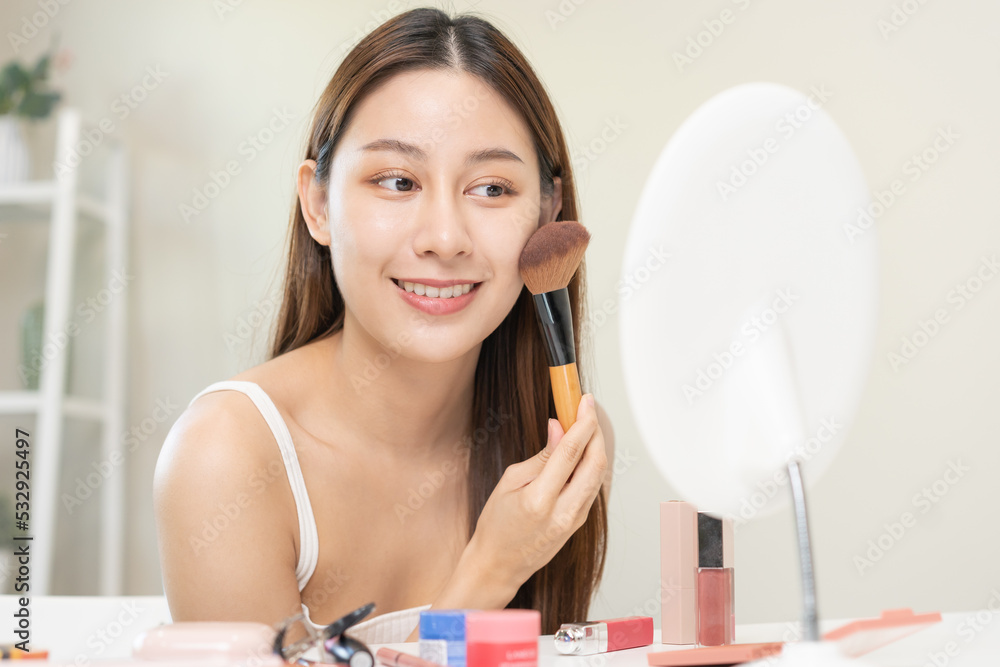 Happy beauty blogger concept, cute asian young woman, girl smile, make up face by applying brush blush powder on her cheek, looking at the mirror. People look with natural fashion style. Happy beauty blogger concept, cute asian young woman, girl smile, make up face by applying brush blush powder on her cheek, looking at the mirror. People look with natural fashion style.