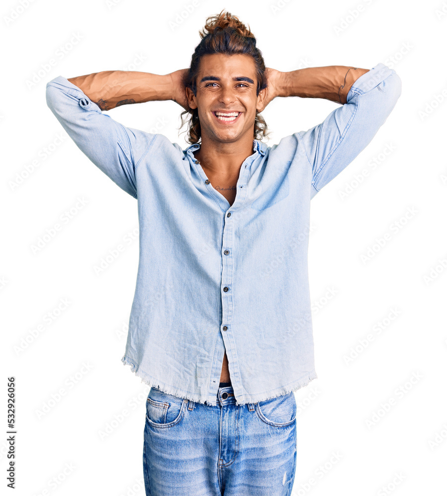 Young hispanic man wearing summer style relaxing and stretching, arms and hands behind head and neck smiling happy Young hispanic man wearing summer style relaxing and stretching, arms and hands behind head and neck smiling happy