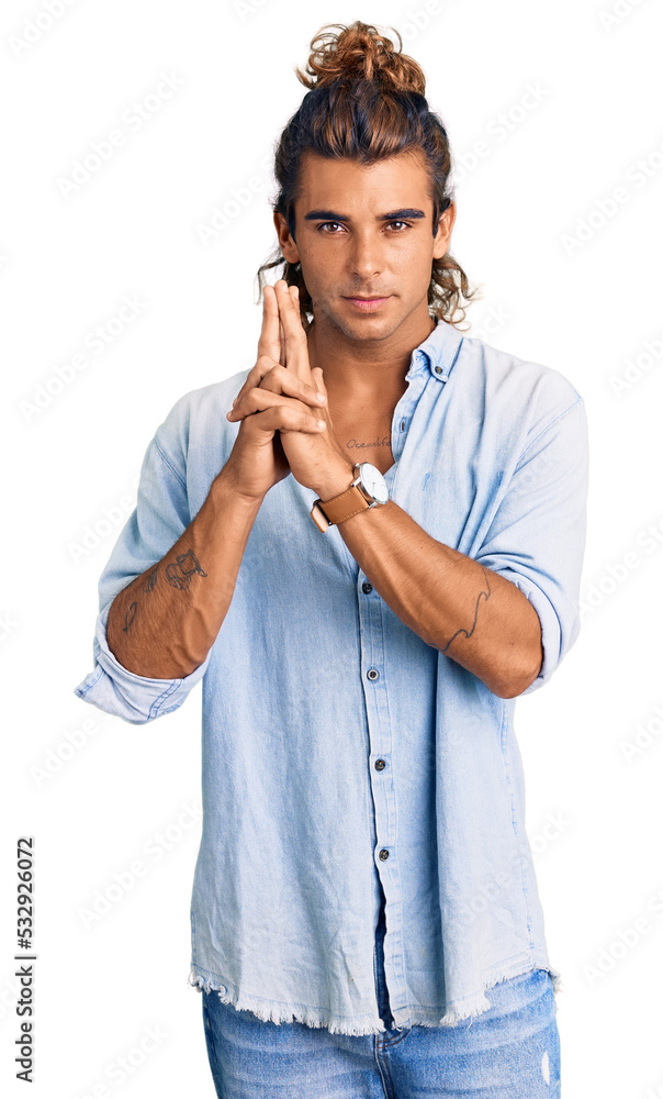 Young hispanic man wearing summer style holding symbolic gun with hand gesture, playing killing shooting weapons, angry face