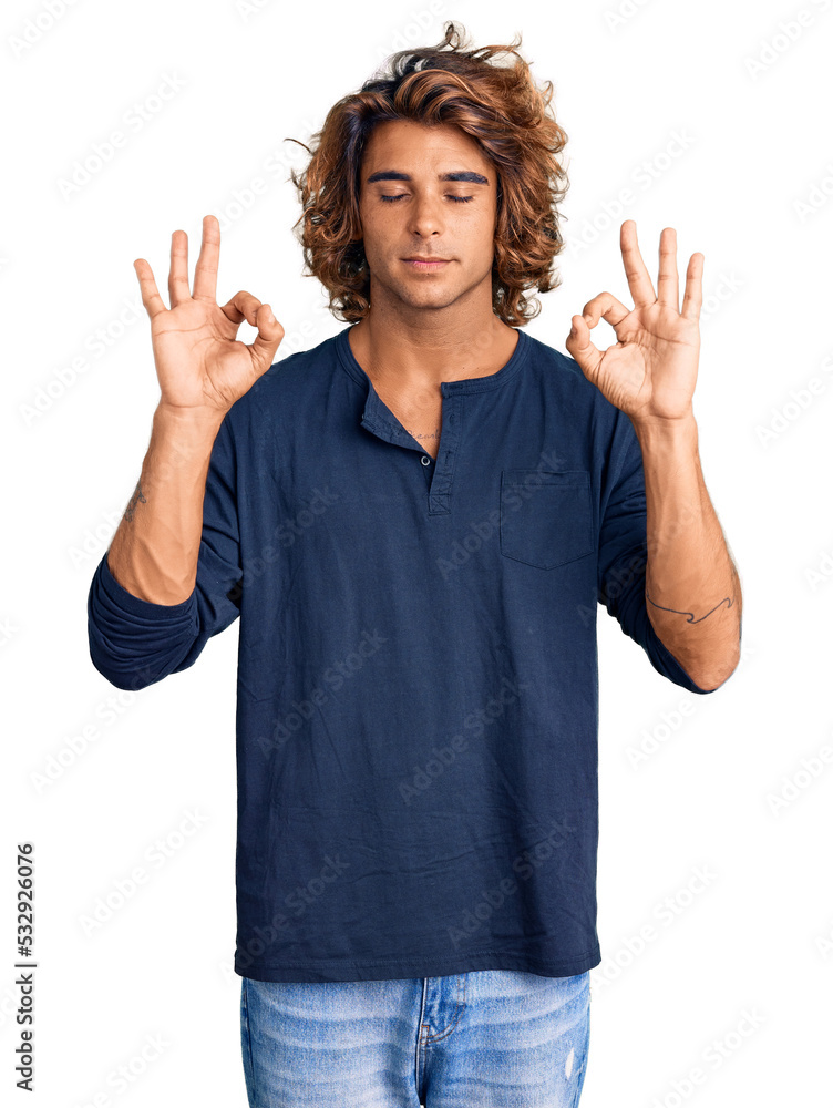Young hispanic man wearing casual clothes relax and smiling with eyes closed doing meditation gesture with fingers. yoga concept. Young hispanic man wearing casual clothes relax and smiling with eyes closed doing meditation gesture with fingers. yoga concept.