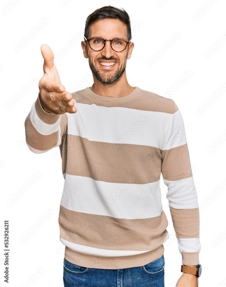 Handsome man with beard wearing casual clothes and glasses smiling friendly offering handshake as greeting and welcoming. successful business. Handsome man with beard wearing casual clothes and glasses smiling friendly offering handshake as greeting and welcoming. successful business.