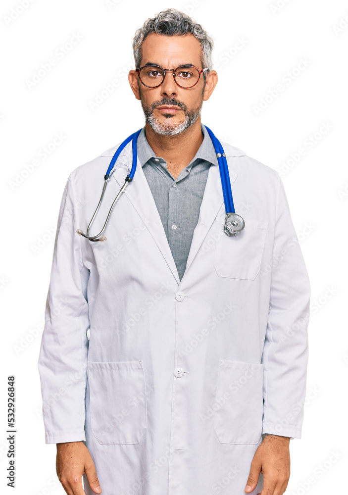 Middle age grey-haired man wearing doctor uniform and stethoscope with serious expression on face. simple and natural looking at the camera. Middle age grey-haired man wearing doctor uniform and stethoscope with serious expression on face. simple and natural looking at the camera.