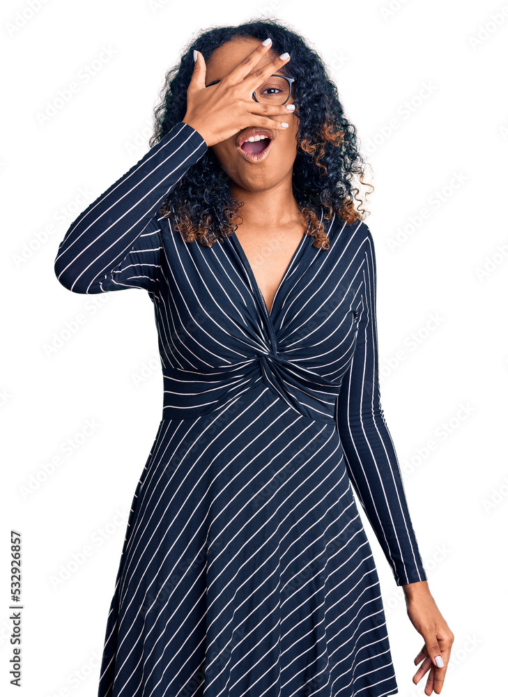 Young african american woman wearing casual clothes and glasses peeking in shock covering face and eyes with hand, looking through fingers with embarrassed expression. Young african american woman wearing casual clothes and glasses peeking in shock covering face and eyes with hand, looking through fingers with embarrassed expression.