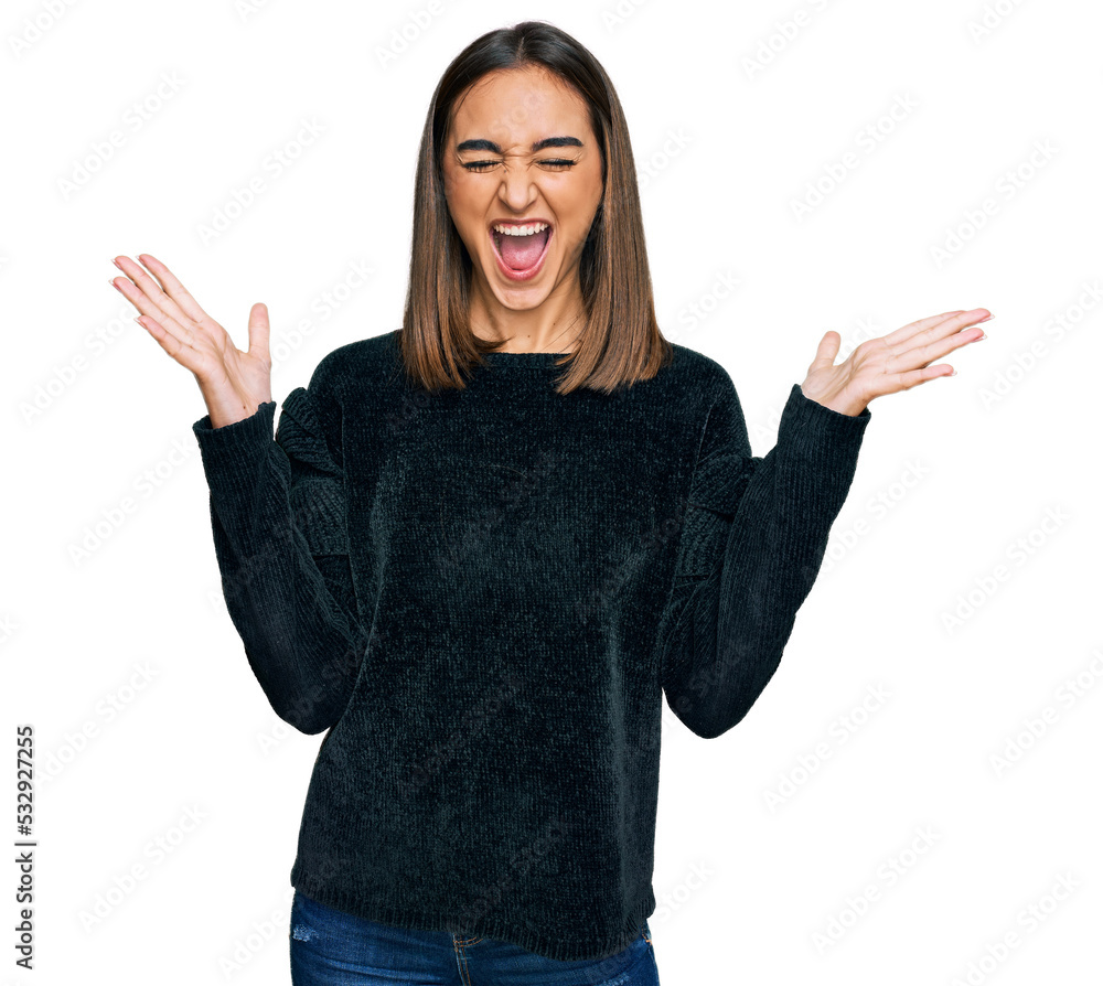 Beautiful brunette woman wearing elegant sweater celebrating mad and crazy for success with arms raised and closed eyes screaming excited. winner concept Beautiful brunette woman wearing elegant sweater celebrating mad and crazy for success with arms raised and closed eyes screaming excited. winner concept