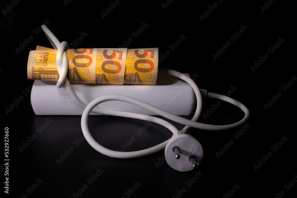 Expensive for electricity consumers. Electrical plugs on euro banknotes on a black background. The concept of expensive electricity costs and the increase in energy bill prices. Expensive for electricity consumers. Electrical plugs on euro banknotes on a black background. The concept of expensive electricity costs and the increase in energy bill prices.