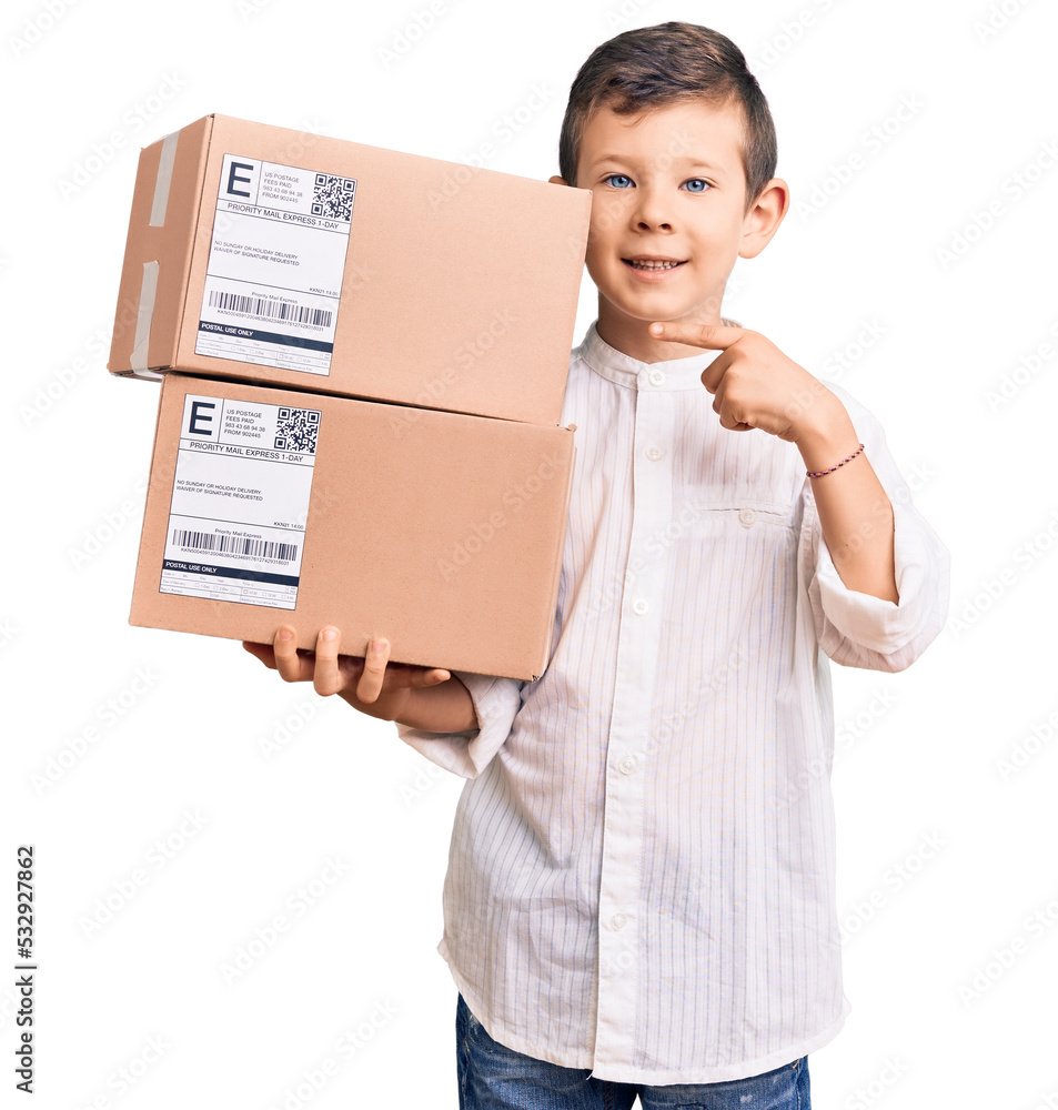 Cute blond kid holding delivery package smiling happy pointing with hand and finger Cute blond kid holding delivery package smiling happy pointing with hand and finger