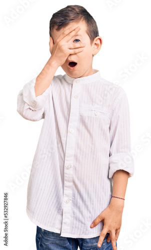 Cuadro en lienzo Cute blond kid wearing elegant shirt peeking in shock covering face and eyes with hand, looking through fingers with embarrassed expression
