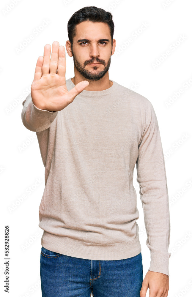 Fototapeta premium Young hispanic man wearing casual clothes doing stop sing with palm of the hand. warning expression with negative and serious gesture on the face.