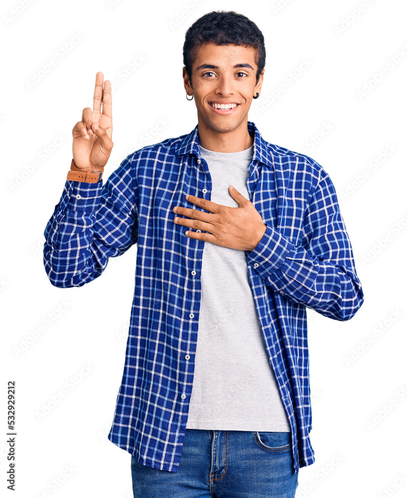 Young african amercian man wearing casual clothes smiling swearing with hand on chest and fingers up, making a loyalty promise oath Young african amercian man wearing casual clothes smiling swearing with hand on chest and fingers up, making a loyalty promise oath