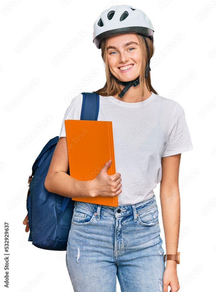 Beautiful young blonde woman wearing backpack and bike helmet looking positive and happy standing and smiling with a confident smile showing teeth Beautiful young blonde woman wearing backpack and bike helmet looking positive and happy standing and smiling with a confident smile showing teeth