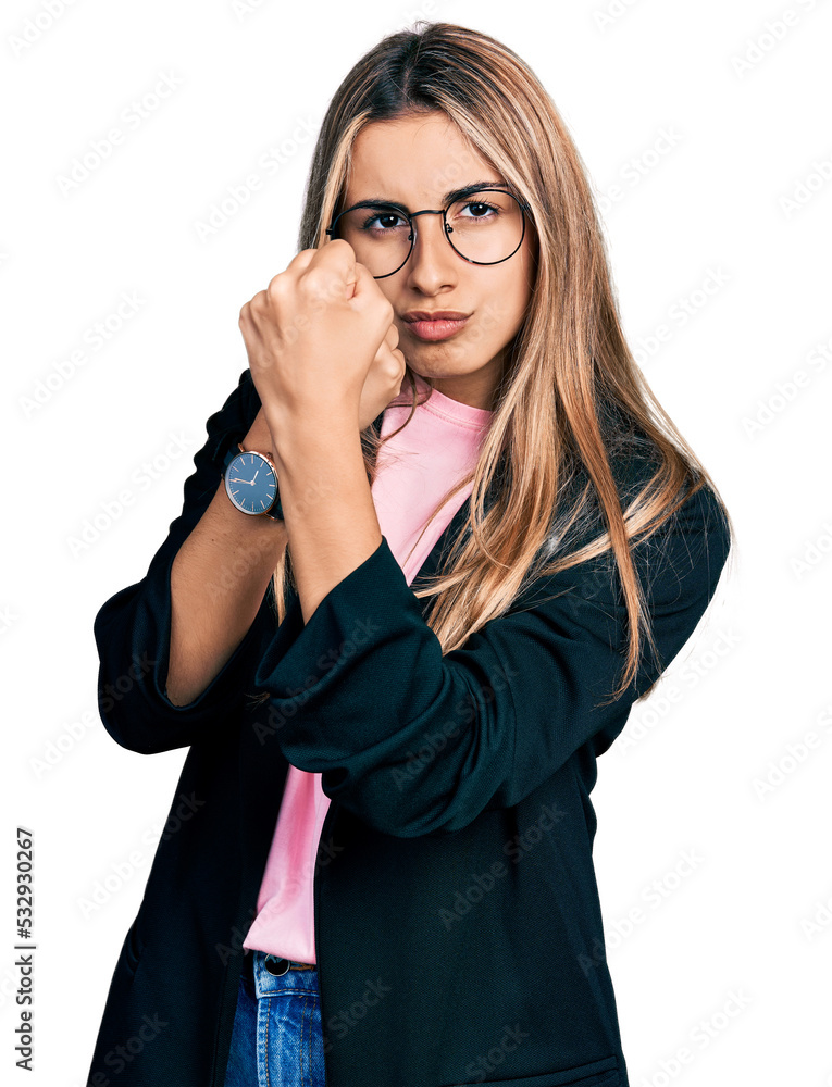 Hispanic young woman wearing business jacket and glasses ready to fight with fist defense gesture, angry and upset face, afraid of problem Hispanic young woman wearing business jacket and glasses ready to fight with fist defense gesture, angry and upset face, afraid of problem