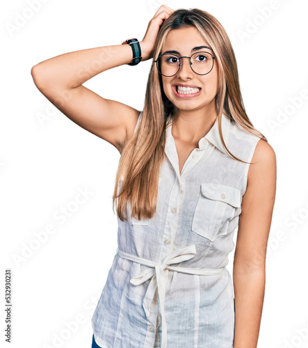 Hispanic young woman wearing casual white shirt confuse and wonder about question. uncertain with doubt, thinking with hand on head. pensive concept.