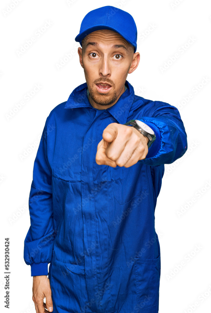 Bald man with beard wearing builder jumpsuit uniform pointing displeased and frustrated to the camera, angry and furious with you