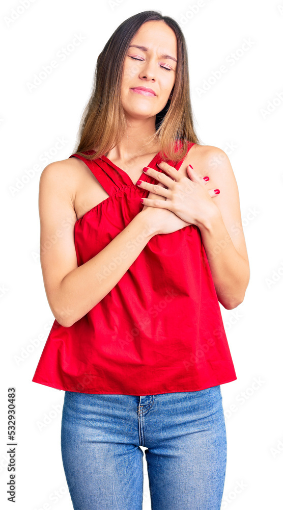 Beautiful brunette young woman wearing casual clothes smiling with hands on chest with closed eyes and grateful gesture on face. health concept. Beautiful brunette young woman wearing casual clothes smiling with hands on chest with closed eyes and grateful gesture on face. health concept.
