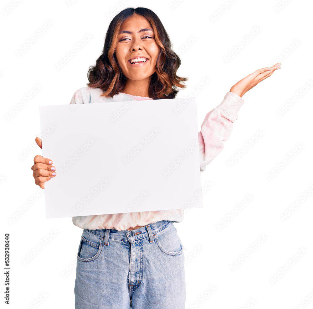 Young beautiful mixed race woman holding cardboard banner with blank space celebrating victory with happy smile and winner expression with raised hands Young beautiful mixed race woman holding cardboard banner with blank space celebrating victory with happy smile and winner expression with raised hands