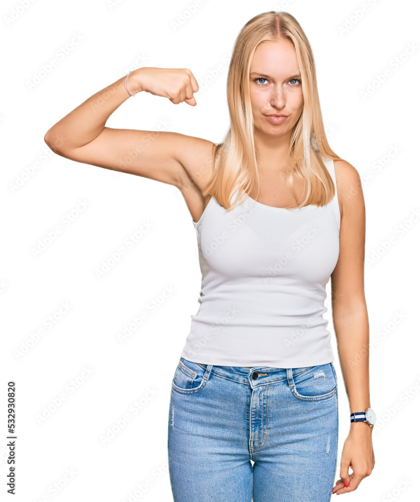 Young blonde girl wearing casual style with sleeveless shirt strong person showing arm muscle, confident and proud of power Young blonde girl wearing casual style with sleeveless shirt strong person showing arm muscle, confident and proud of power