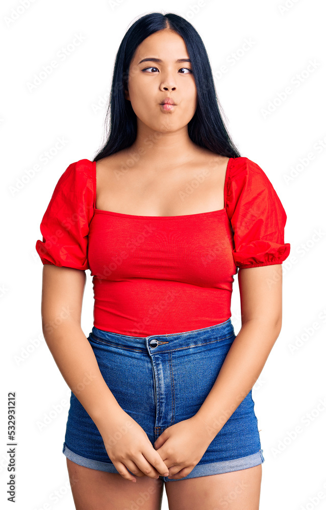 Fototapeta premium Young beautiful asian girl wearing casual clothes making fish face with lips, crazy and comical gesture. funny expression.