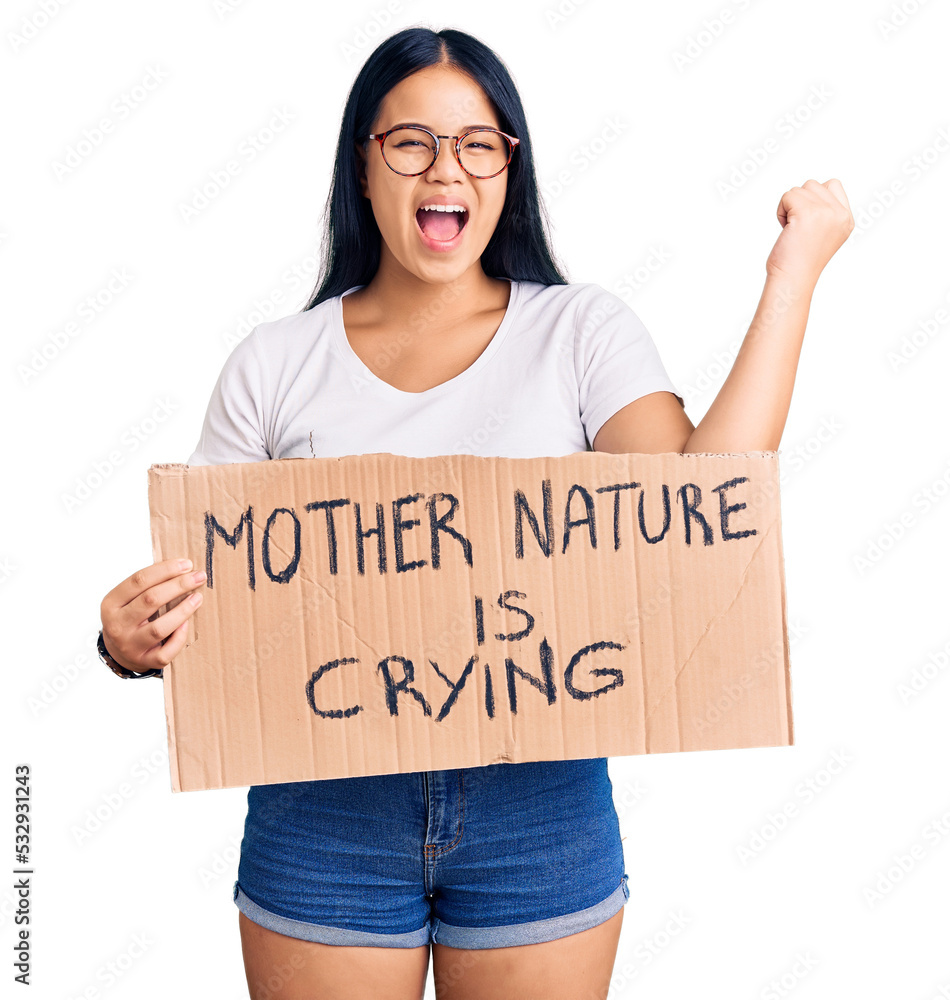 Young beautiful asian girl holding mother nature is crying protest cardboard banner screaming proud, celebrating victory and success very excited with raised arms Young beautiful asian girl holding mother nature is crying protest cardboard banner screaming proud, celebrating victory and success very excited with raised arms
