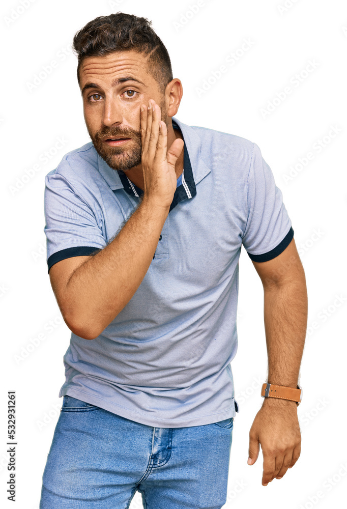 Handsome man with beard wearing casual clothes hand on mouth telling secret rumor, whispering malicious talk conversation Handsome man with beard wearing casual clothes hand on mouth telling secret rumor, whispering malicious talk conversation