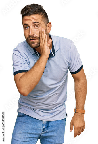 Handsome man with beard wearing casual clothes hand on mouth telling secret rumor  whispering malicious talk conversation