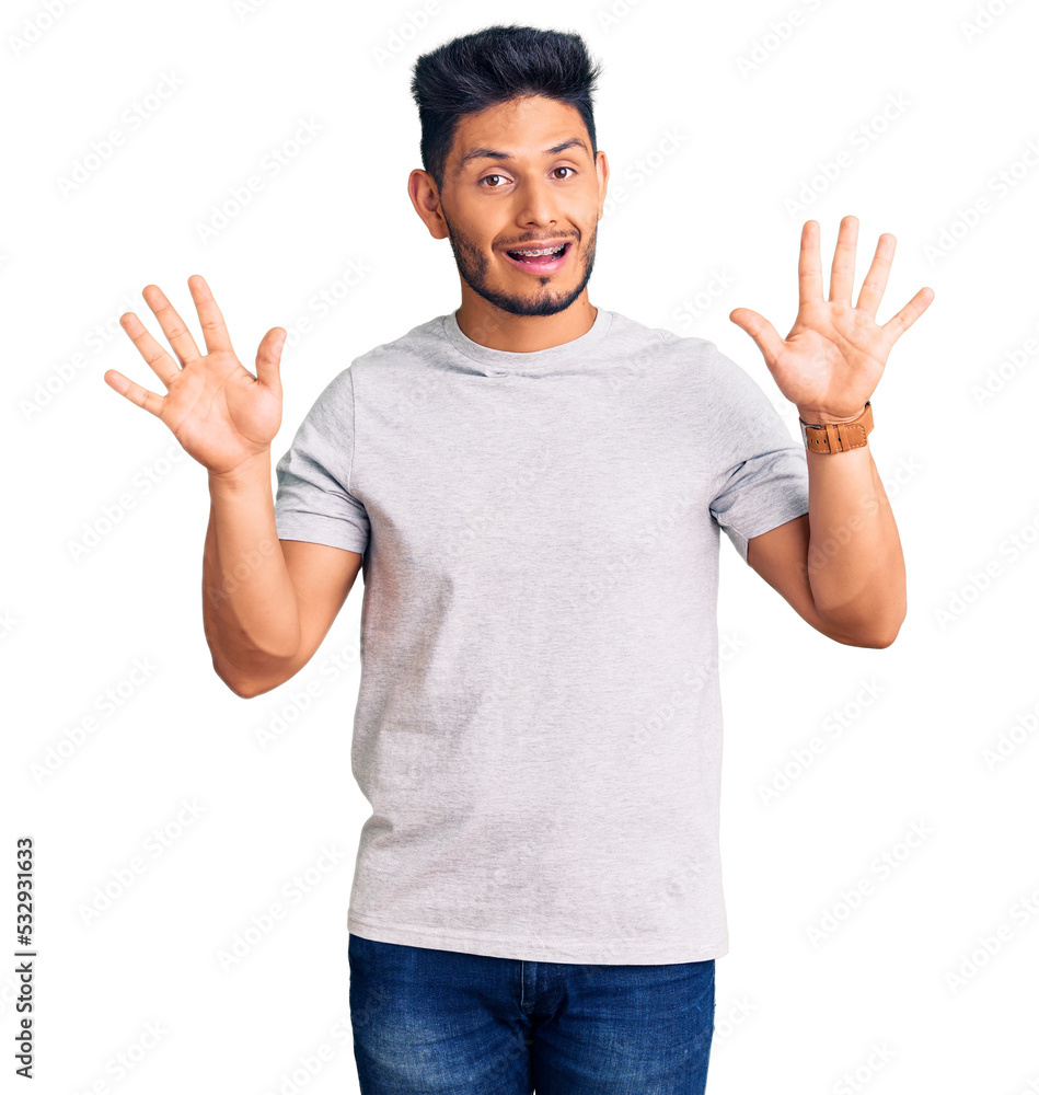 Handsome latin american young man wearing casual tshirt showing and pointing up with fingers number ten while smiling confident and happy. Handsome latin american young man wearing casual tshirt showing and pointing up with fingers number ten while smiling confident and happy.